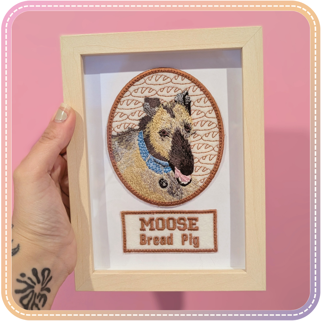 embroidery of a dog called Moose in a small pale wood coloured frame