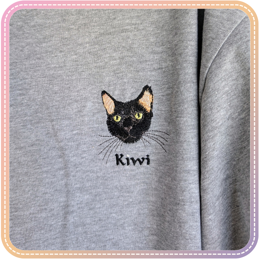close up of an embroidered tshirt of a black cat named kiwi