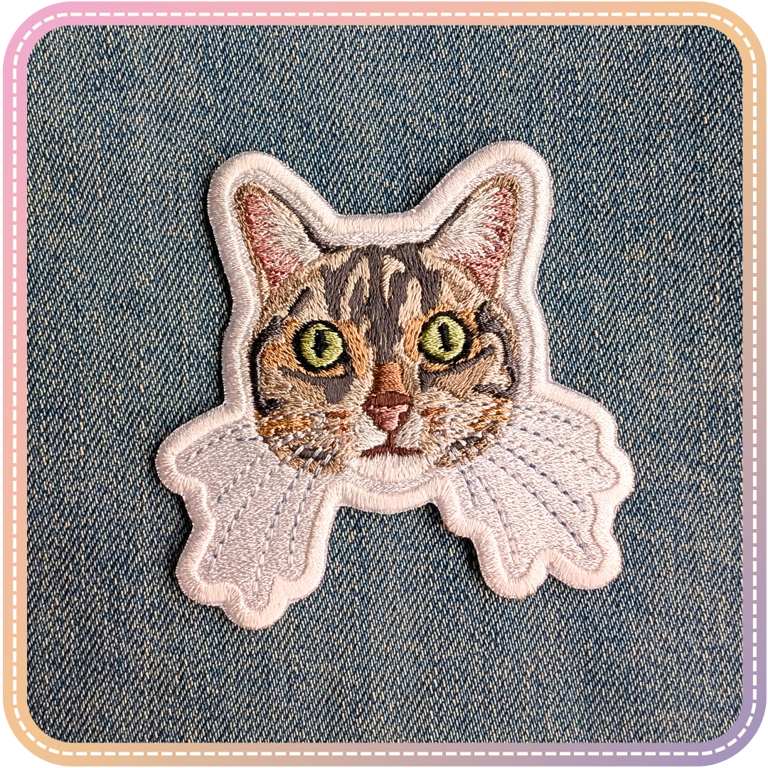 An embroidery patch of Morgan, a grey and brown tabby cat